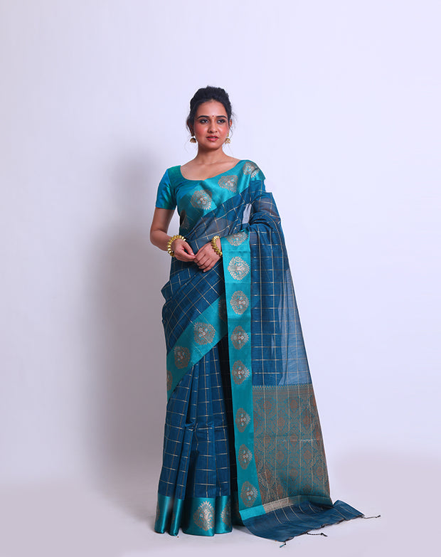 The Blue Fancy Cotton saree with Zari checks all over the drape and a Zari-woven pallu sounds absolutely exquisite - FCT011143