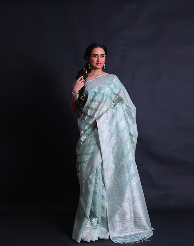 The light green pure kora saree radiates elegance with its intricate silver zari and thread work adorning the entirety of the drape,- BSK010527