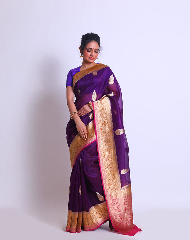 The Purple Organza Handloom saree with a combination of gold border and pink selvage on the border and pallu sounds absolutely elegant - BSK010257