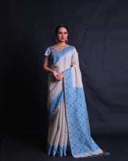 The Beige blended Tussar cotton saree with small buttis of zari and blue thread all over the drape,-  BLN01371