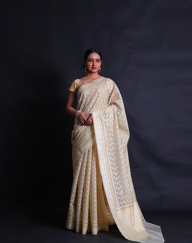 The beige kora cotton saree you described is adorned with white and zari thread woven all over the drape,- BSK010448