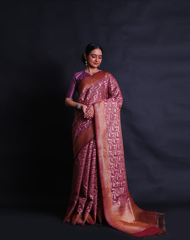 The pink Banarasi saree you're describing is adorned with antique zari woven throughout the drape,- BSK010674