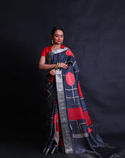 The black Desi Tussar saree featuring a zari border and pallu exudes timeless elegance.- PTS05292