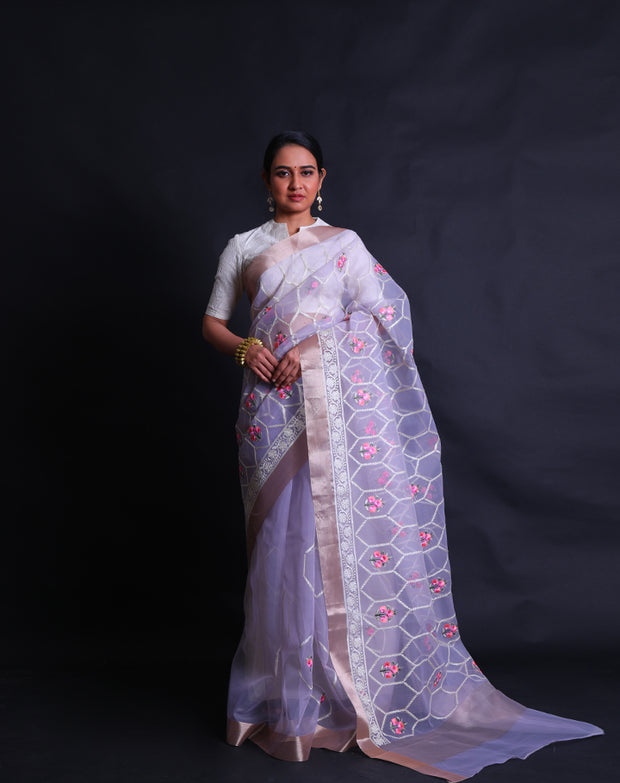 The light mauve organza saree with thread machine embroidery in white and colorful flowers all over the drape,- BLN01555