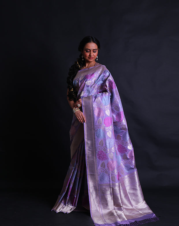 The light mauve Banarsi silk saree exudes elegance with its intricate leafy design woven delicately in zari and thread,- BSK010512