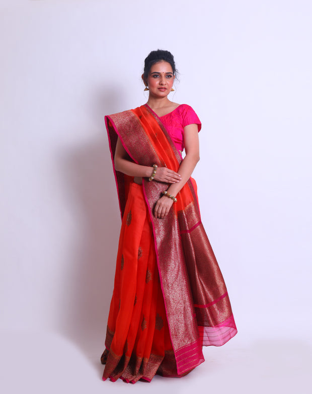 The Orange Organza Handloom saree with a contrast rani color border and pallu featuring antique zari weaving sounds stunning - BSK010449