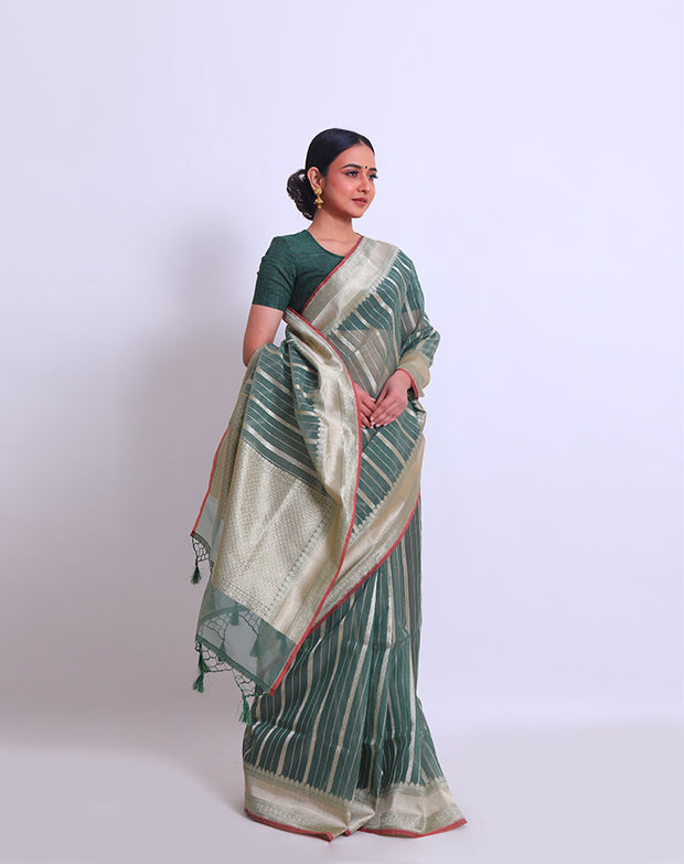 The green semi-organza saree with a zari border and pallu, adorned with green tassels and a pink selvage - FCT011113