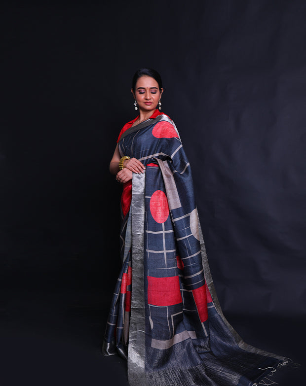 The black Desi Tussar saree featuring a zari border and pallu exudes timeless elegance.- PTS05292