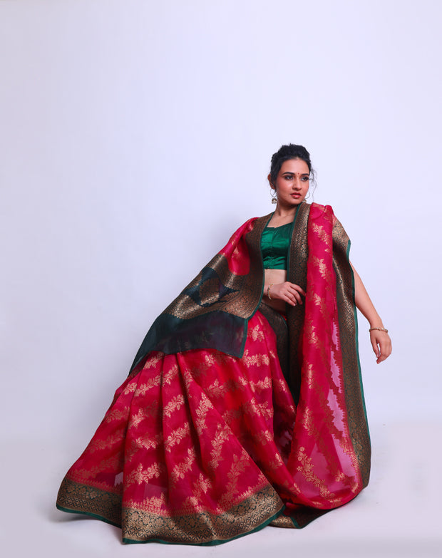 A Rani Pink organza Handloom saree with a contrast bottle green border and pallu featuring antique Zari sounds stunning - BSK010617