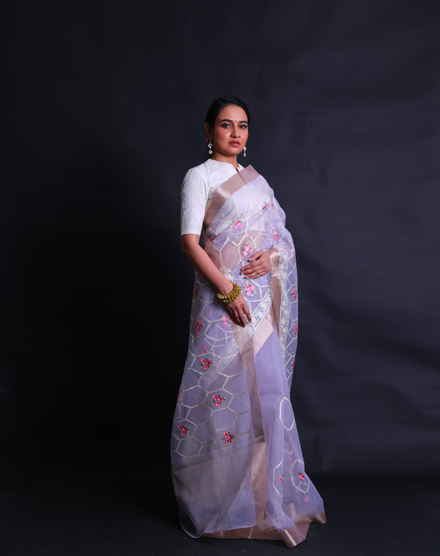 The light mauve organza saree with thread machine embroidery in white and colorful flowers all over the drape,- BLN01555