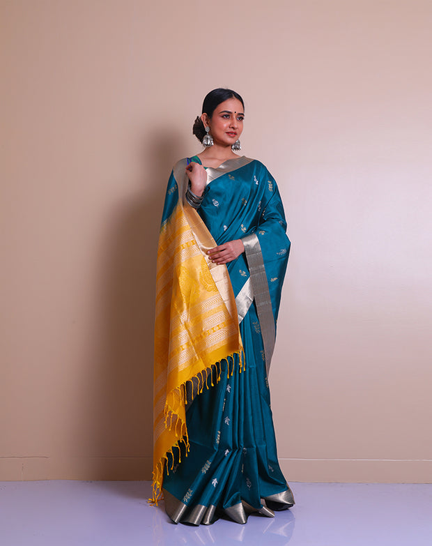 The peacock blue Kanjivaram saree with a gold and silver zari border sounds absolutely regal. - KSL03070