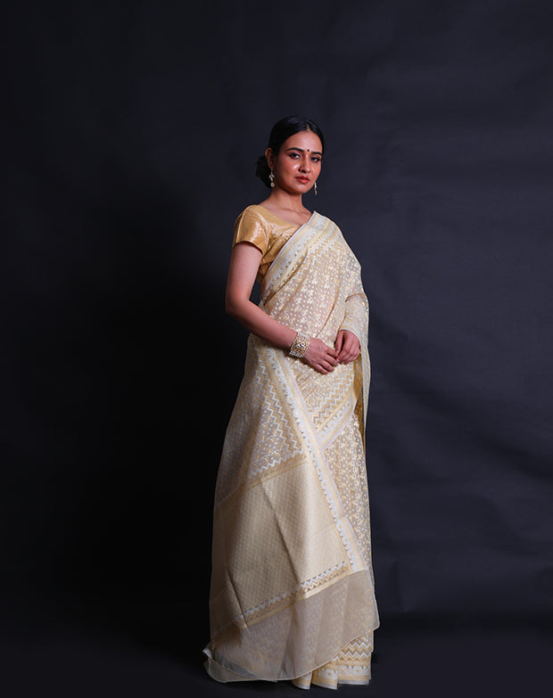 The beige kora cotton saree you described is adorned with white and zari thread woven all over the drape,- BSK010448