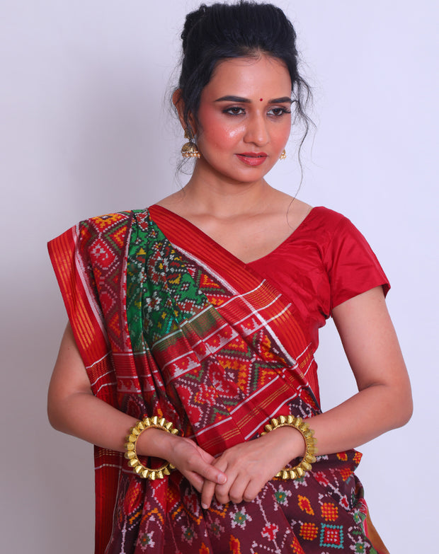 A green double Patola silk saree with a contrast maroon Patola design on the border and pallu must create a striking look - RPT00797
