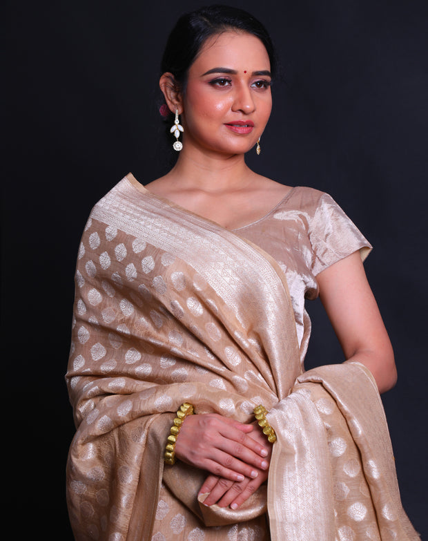 The beige Banarasi linen Khadi georgette saree adorned with silver zari buttis all over the drape,- CHG04026