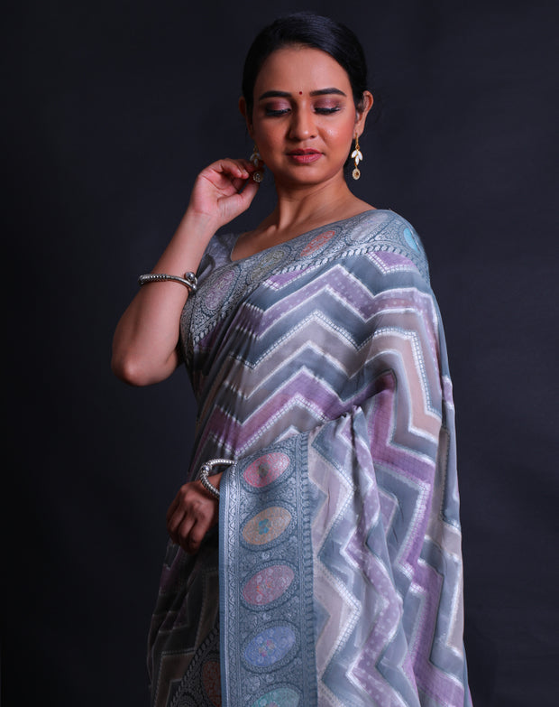 The grey semi Khadi georgette saree with light shades and zari lines in a zig-zag design,- CHG04011