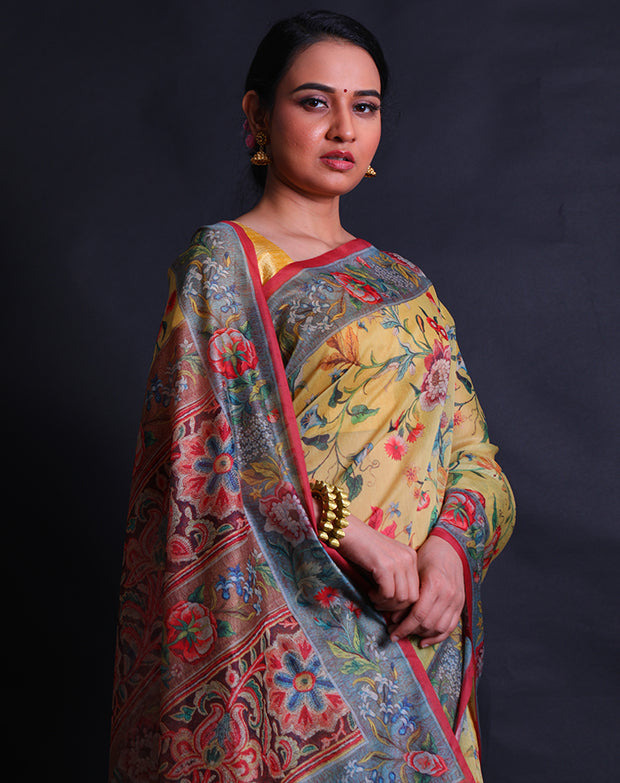 The mustard blended cotton saree with a colorful flower design printed in digital all over the drape sounds vibrant and charming,- BLN01345