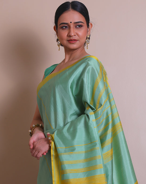 The saree is a lovely image of a sea green Kanjivaram silk saree with mustard accents - KSL03110