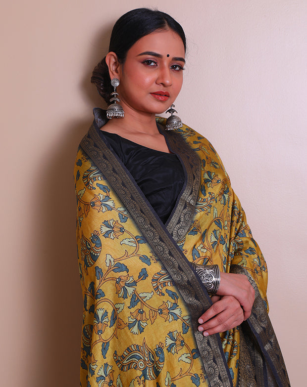 The mustard blended saree with Kalamkari print, featuring a zari border and pallu with tassels - BLN01331