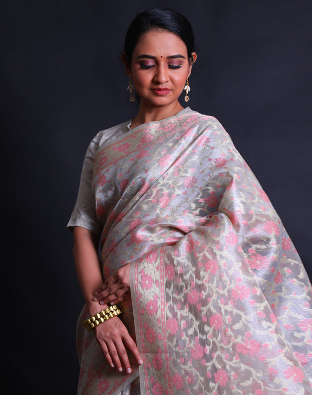 The beige tissue cotton saree with zari and pink thread woven in flower design all over the drape sounds elegant and refined,- FCT011109